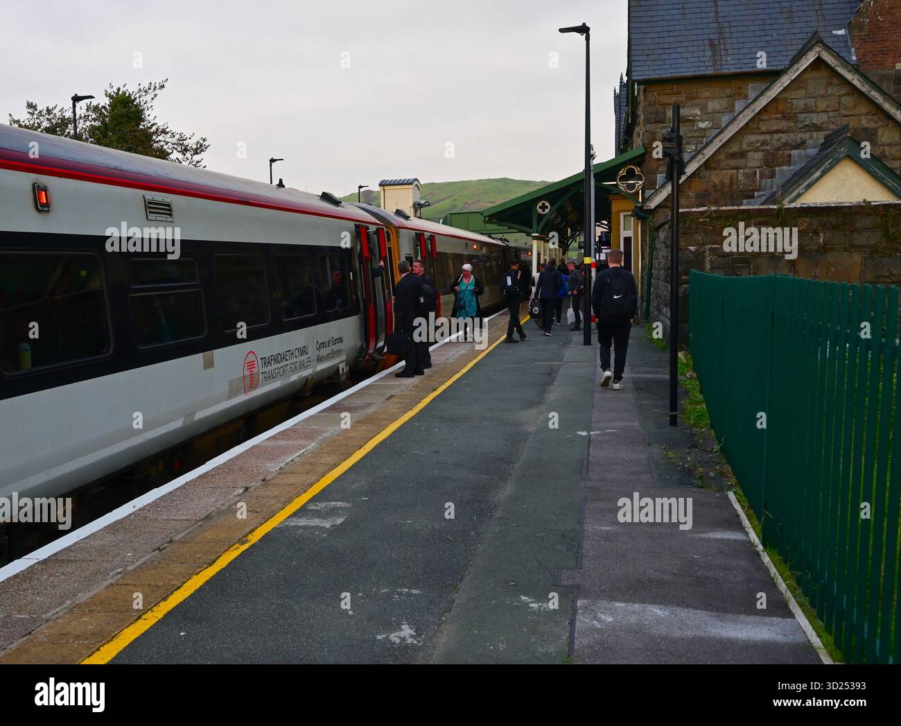 Transport pour le train du pays de Galles arrivant à la gare de Machynlleth avec des personnes sur le quai. Banque D'Images