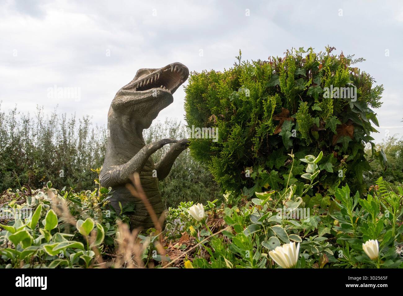 Figures de statues de dinosaures s'élevant d'une haie à Seaton, Devon, Angleterre. Figurines de la côte jurassique Banque D'Images
