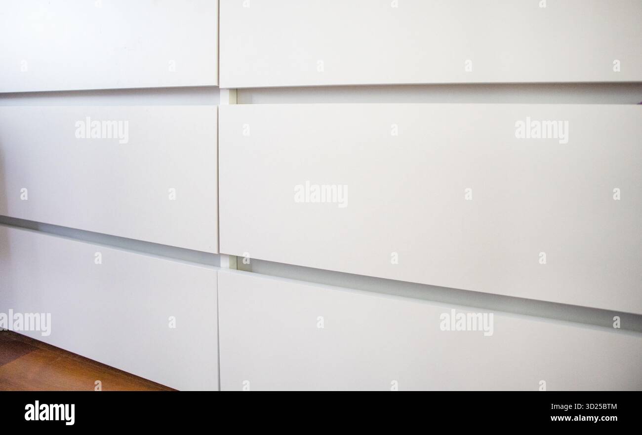 Façades de tiroir sans main plates blanches avec plancher en bois chaud Fermer le cadre horizontal intérieur moderne minimal personne, organisation de la maison, désencombrement, Banque D'Images