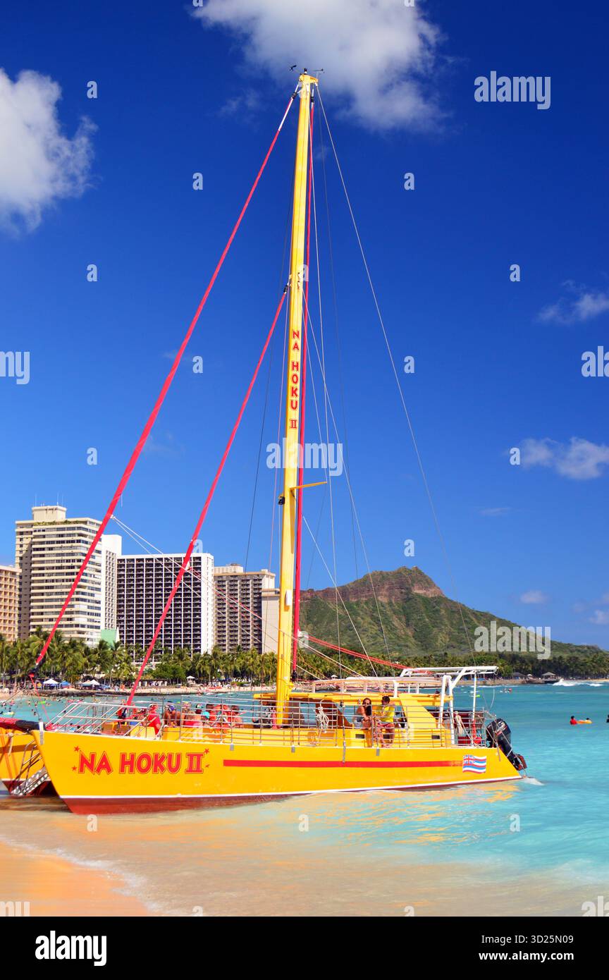 Waikiki Beach, HI, États-Unis juillet 31. 2014 Un catamaran jaune repose sur les sables de Waikiki Beach, Hawaï prêt à prendre le prochain groupe d'aventuriers Banque D'Images