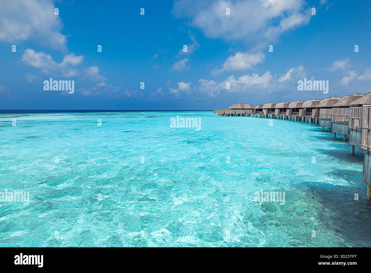 Villas aquatiques de luxe Maldives sur l'océan turquoise avec ciel clair, destination de vacances tropicales d'été, vue sereine de la station balnéaire pour les voyages, vacances touristiques Banque D'Images