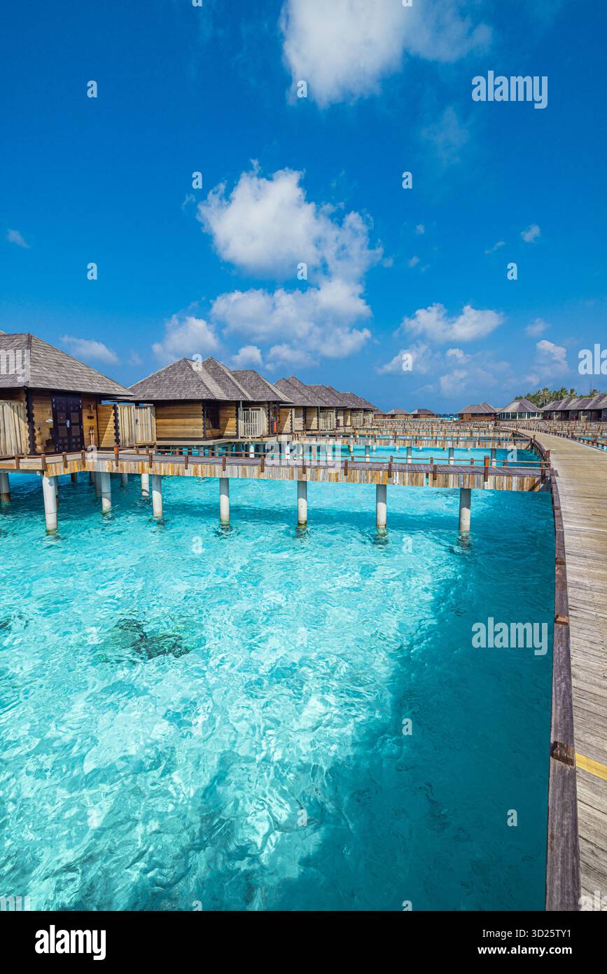 Villas aquatiques de luxe Maldives sur l'océan turquoise avec ciel clair, destination de vacances tropicales d'été, vue sereine de la station balnéaire pour les voyages, vacances touristiques Banque D'Images