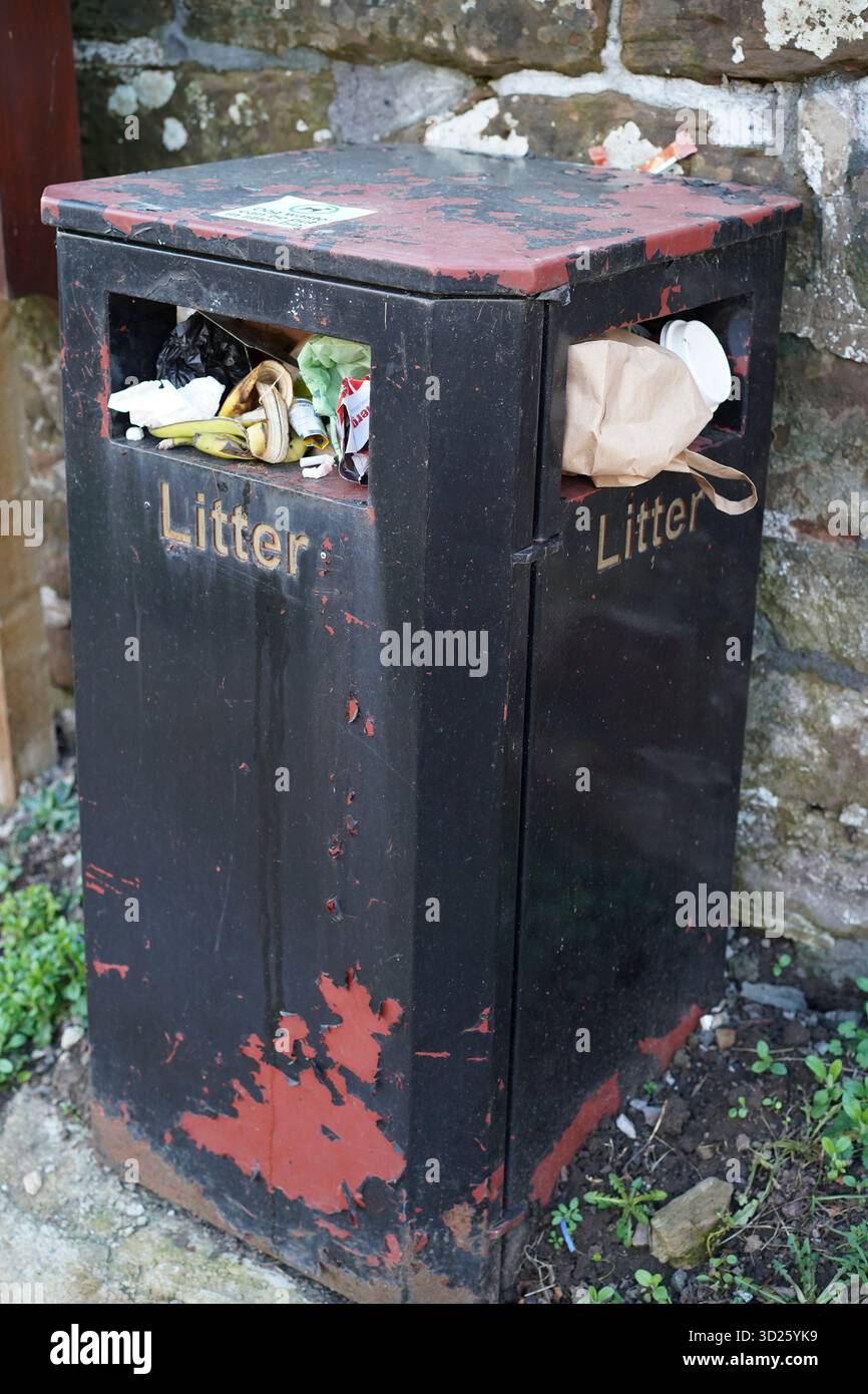 Poubelle extérieure remplie de déchets et débordant par les ouvertures supérieures. Banque D'Images