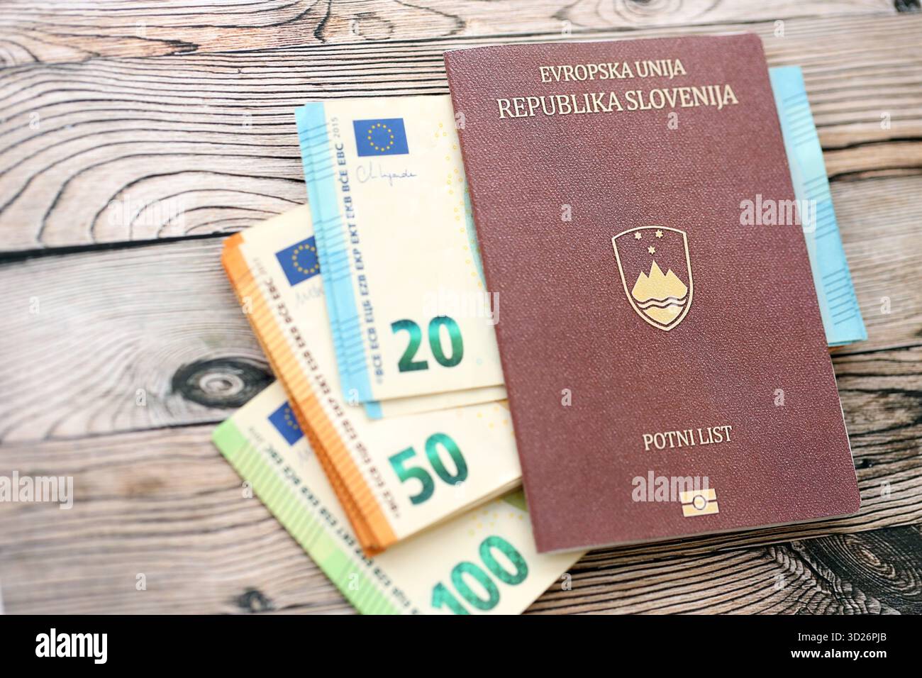 Passeport slovène se trouve avec des billets de banque en euros sur fond de bois gros plan. Espèces et paiements en Europe concept Banque D'Images