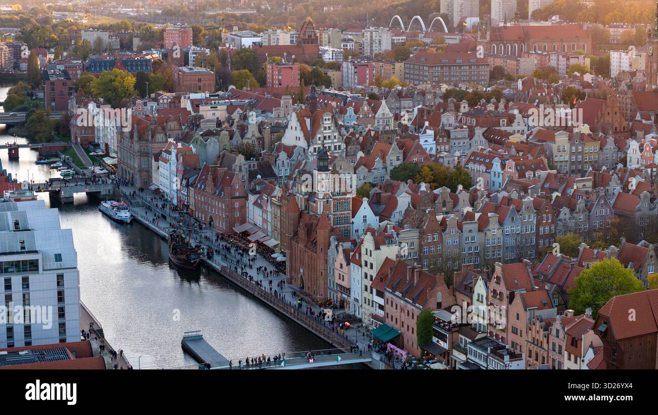 Vue aérienne de la vieille ville de Gdansk sur la rivière Motlawa. L'église St Marys s'élève au-dessus des toits, la grue Zuraw se tient près du quai et les bateaux d'excursion glissent sous les toits Banque D'Images