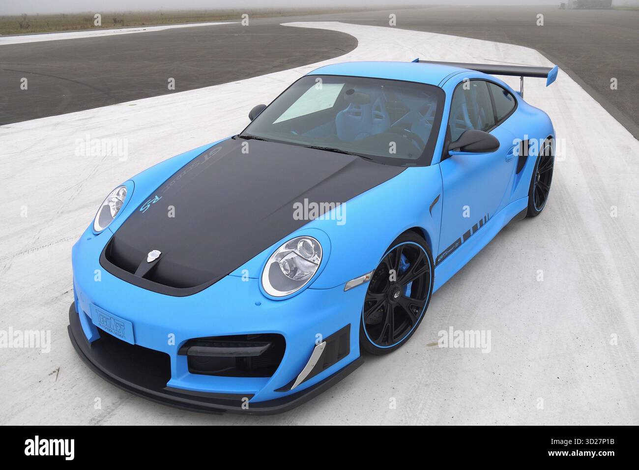 Techart GTStreet RS modifié Porsche 911. Voiture bleue, capot noir, sur route blanche sinueuse spectaculaire. Banque D'Images