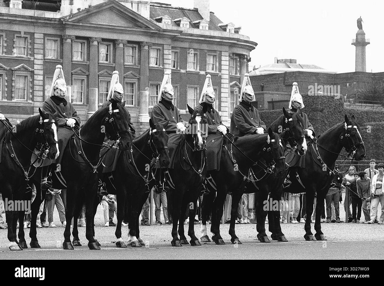 Un tableau intemporel à Horse Guards Parade, Londres. L'emblématique Household Cavalry, vêtu de leurs casquettes en peau d'ours distinctives et de leurs uniformes écarlate, attire l'attention sur la toile de fond de la grande architecture de Whitehall. Symbole de la tradition britannique et de la précision militaire, cette image capture un moment de cérémonie majestueuse au cœur de Londres. Banque D'Images