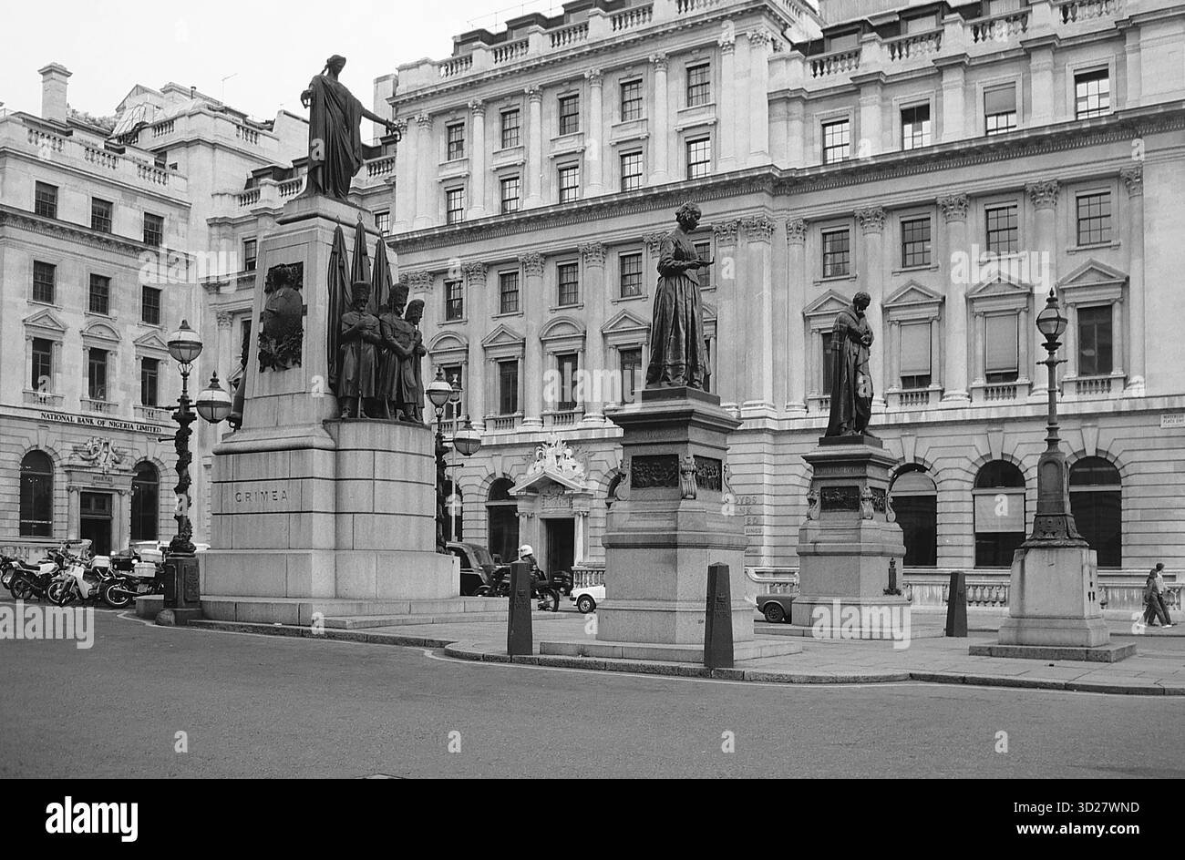 Une scène majestueuse se déroule au cœur de Londres, où une statue monumentale se dresse fièrement devant un grand bâtiment victorien. Les détails complexes de la statue et de ses piliers de soutien sont juxtaposés contre la façade texturée du bâtiment, créant un portrait intemporel de l'architecture britannique. Ce monument emblématique capture l'essence de l'histoire et de la grandeur de Londres, un témoignage de l'héritage durable de la ville. Banque D'Images