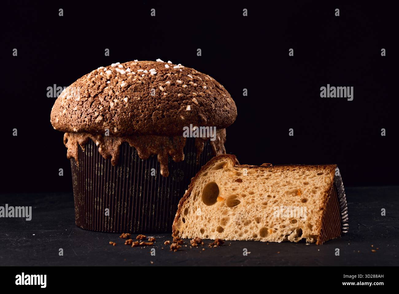 Panettone gâteau italien de Noël, pain doux traditionnel sucré avec des noix, des raisins secs et du chocolat sur fond noir Banque D'Images