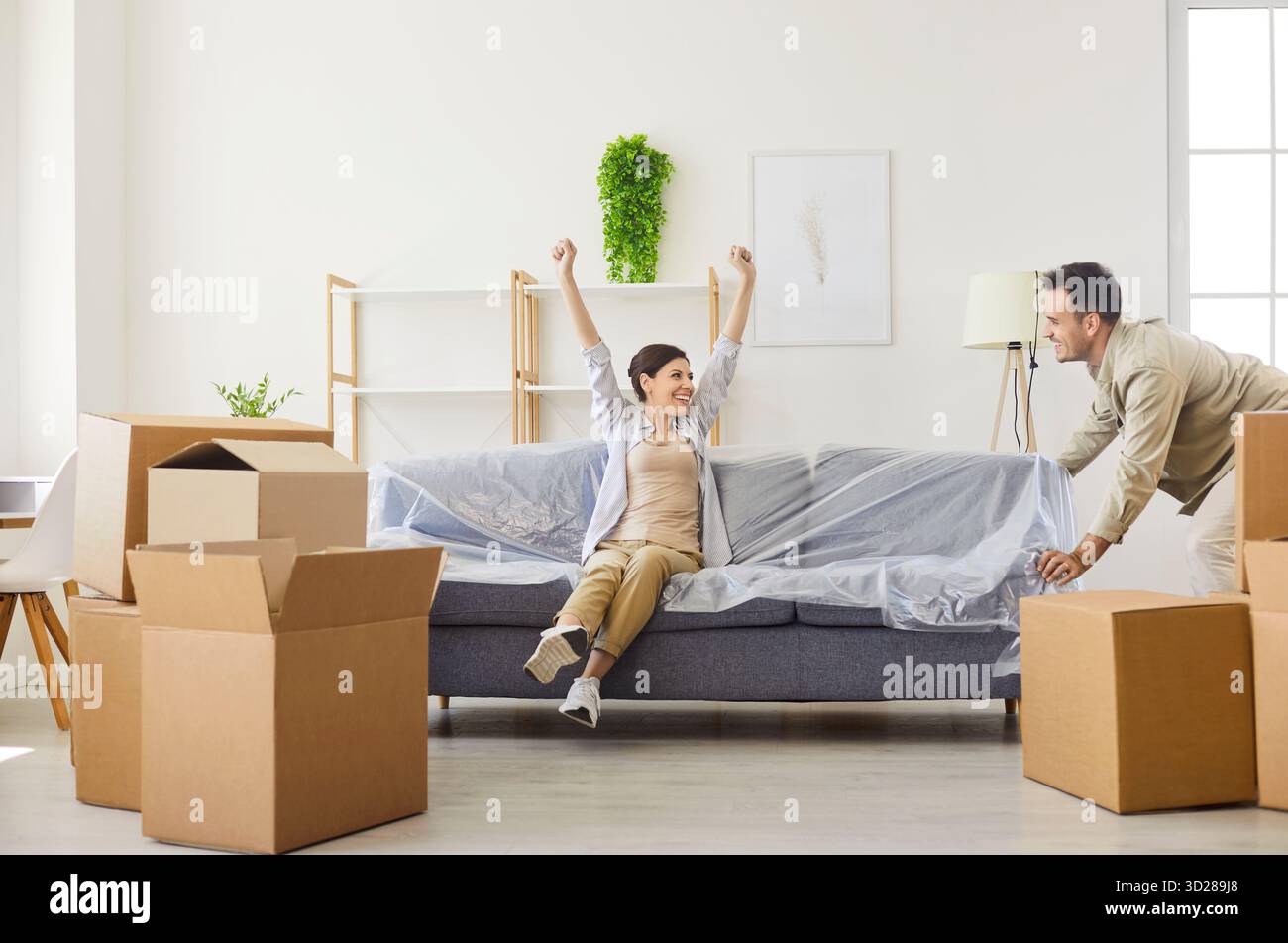 Déménagement d'un couple heureux emménageant dans une nouvelle maison, les gens de la famille déplacent des meubles Banque D'Images