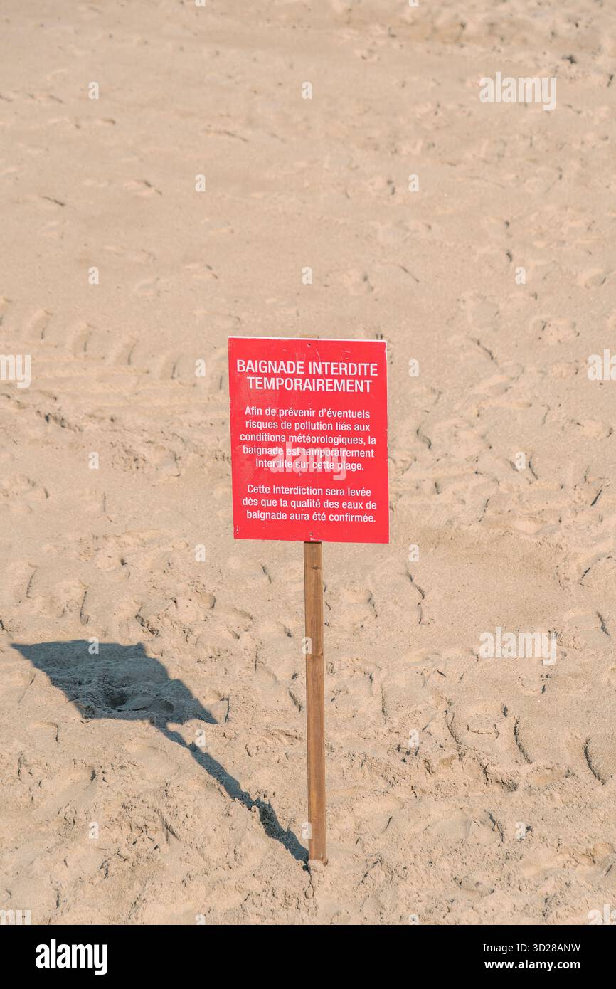 Panneau d'avertissement rouge sur Sandy Beach, avis d'interdiction temporaire de baignade, alerte sur la qualité de l'eau, prévention des risques de pollution, sécurité environnementale, fermeture de plage Banque D'Images