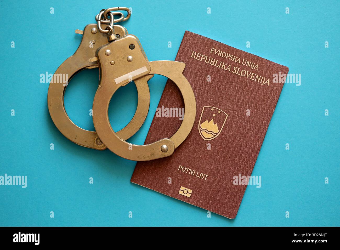 Passeport slovène avec menottes de police sur la table de près. Niveau de criminalité et arrestations en Europe concept Banque D'Images