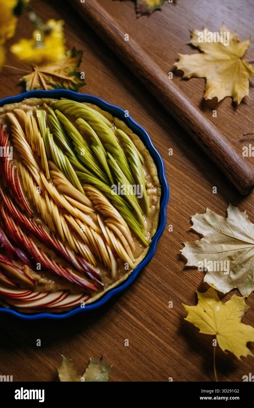 Tarte aux pommes non cuite décorée de tranches de fruits colorées Banque D'Images