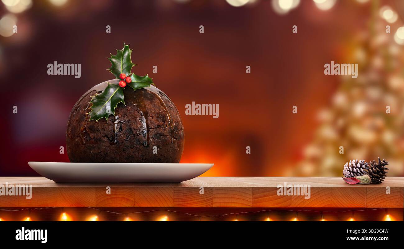 Une vue de niveau d'un pudding de Noël traditionnel sur une assiette ronde avec un brin de houx, des baies sur une table en bois sur un fond festif sombre. Banque D'Images
