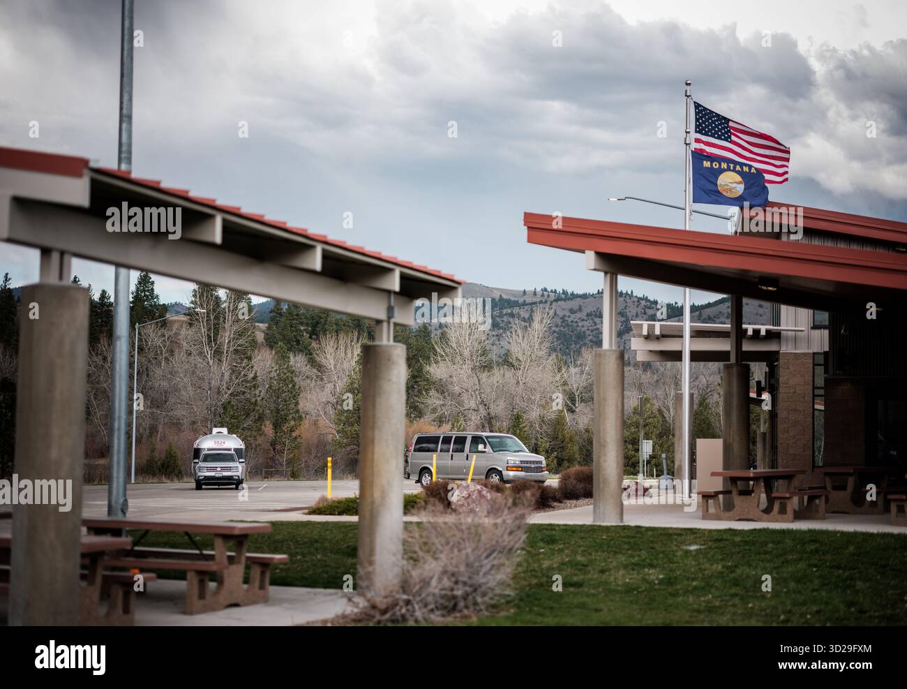 Remorque de voyage Airstream et véhicule de remorquage à un arrêt de repos inter-états avec ciel sombre dans le Montana, États-Unis, Amérique du Nord. Banque D'Images