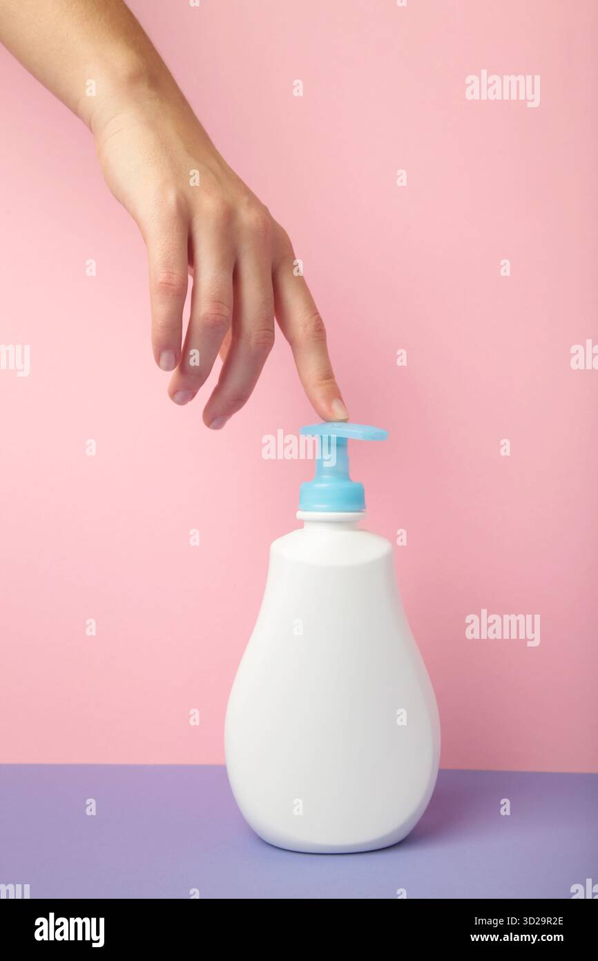 Un savon liquide pour les mains avec une lotion de pompage de la bouteille. Hygiène femme se laver les mains concept. Photo verticale Banque D'Images