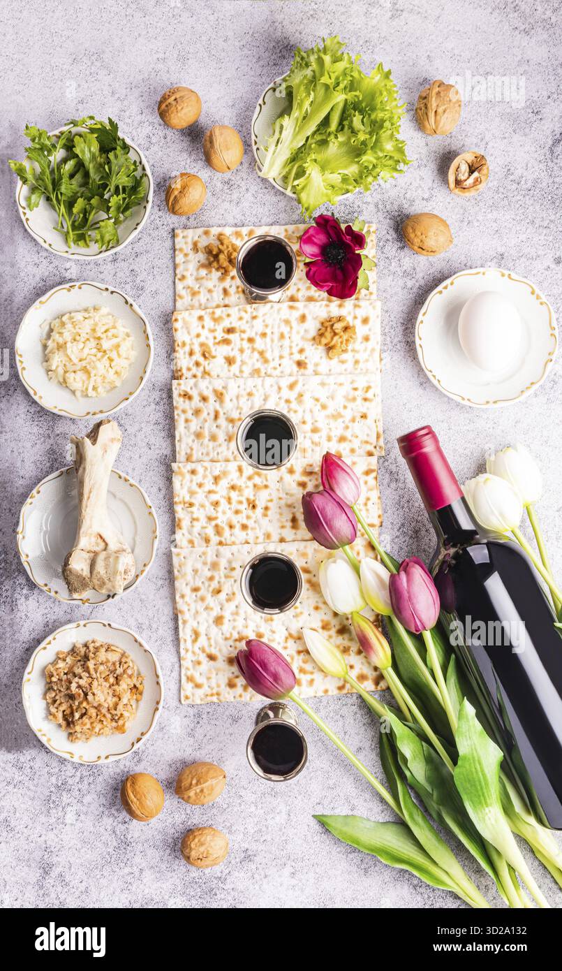 Disposition plate de produits traditionnels pour la fête de la Pâque juive. Vin, pain matzoth, persil, laitue, oeuf, os. Vue verticale de dessus Banque D'Images