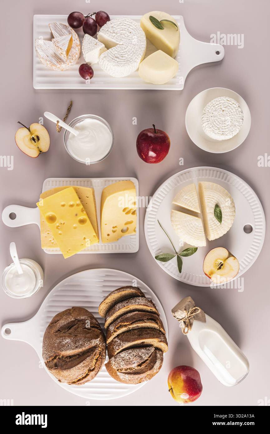 Produits laitiers frais, pain, fromage, fromage cottage, crème sure sur différents tableaux blancs. Vue verticale de dessus. Pose à plat. Le concept de Shavuot Banque D'Images