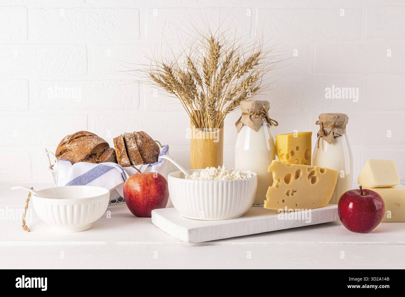 A produits laitiers frais, crème sure, fromage, lait, pommes à pain et épis de maïs dans un vase pour les vacances de Shavouot juif. Vue de face Banque D'Images