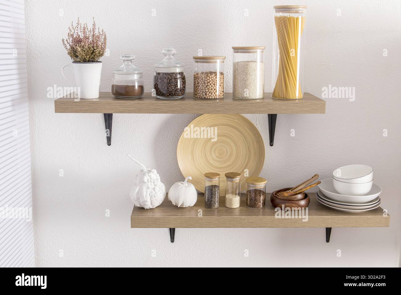 Ouvrez les étagères en bois avec divers bocaux en verre avec un couvercle en bois rempli d'épices, de café, de spaghettis. décoration élégante dans la cuisine moderne. vue de face Banque D'Images