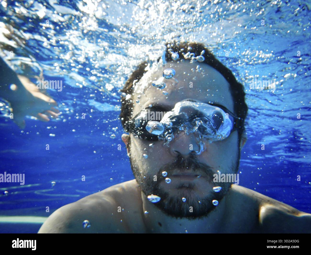 Homme nager sous l'eau dans la piscine Banque D'Images