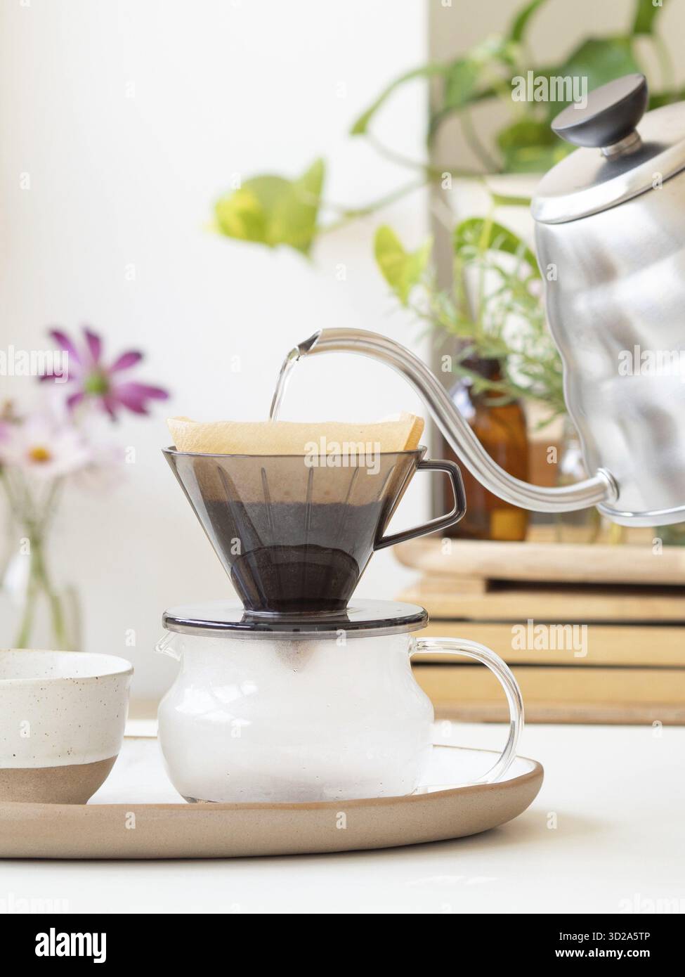 L'eau chaude étant versée d'une bouilloire moderne dans un filtre à café, préparant une tasse de café fraîche Banque D'Images