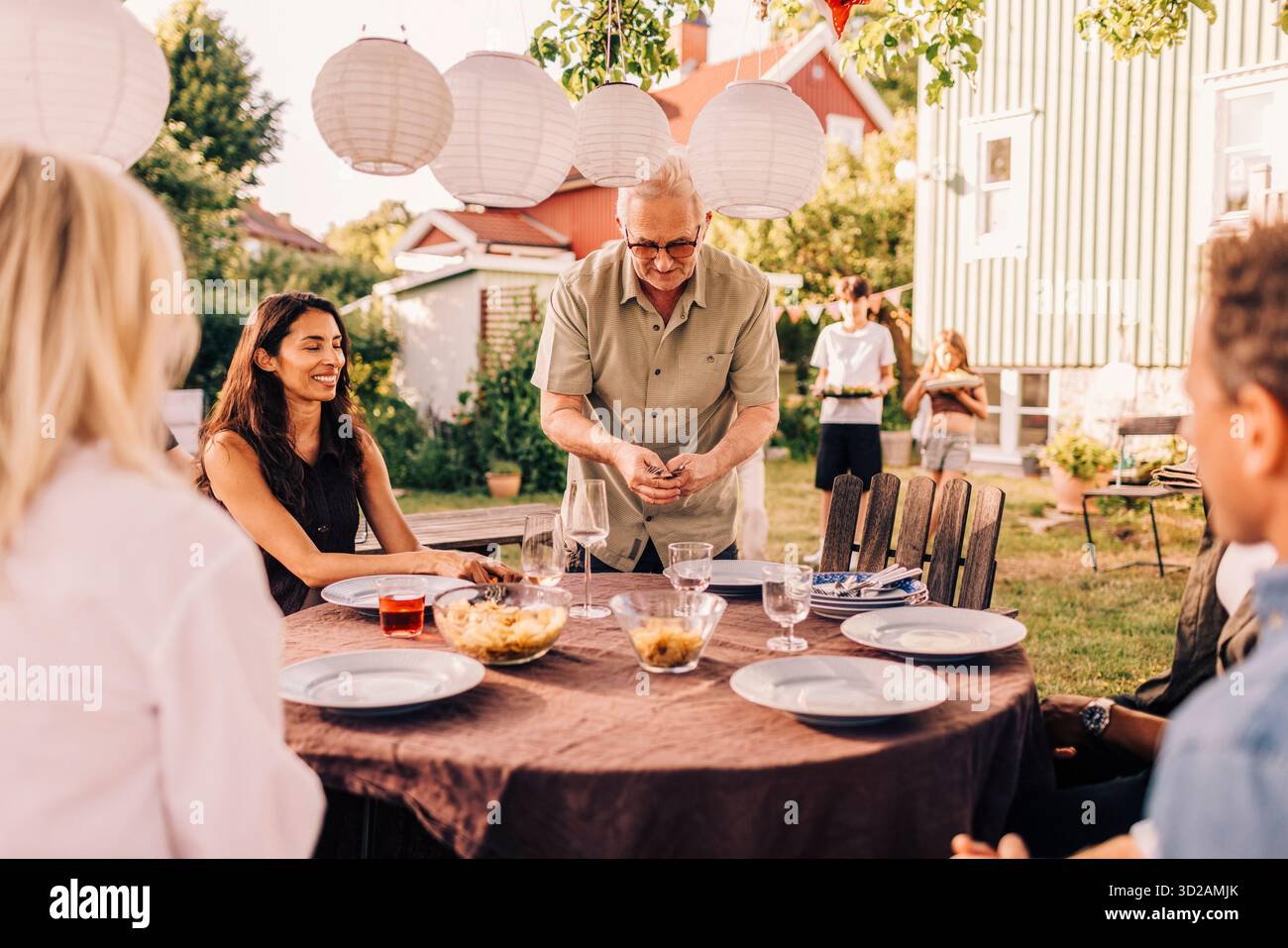 Homme senior actif table de réglage pour les amis de la famille à la fête de jardin de rassemblement social Banque D'Images