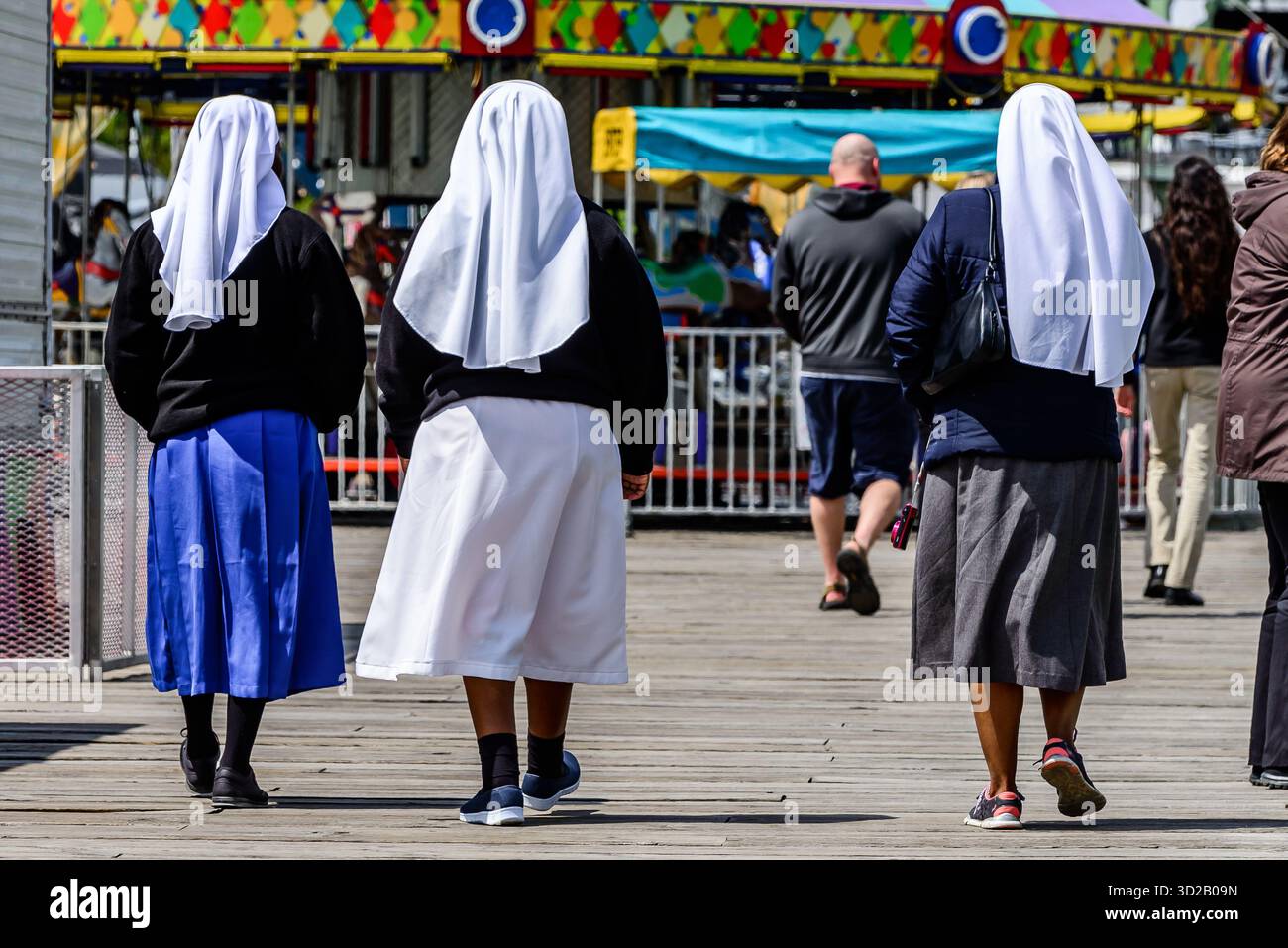 Trois femmes portant des couvre-têtes blancs marchent le long de la promenade à Canalside, Buffalo NY. Banque D'Images