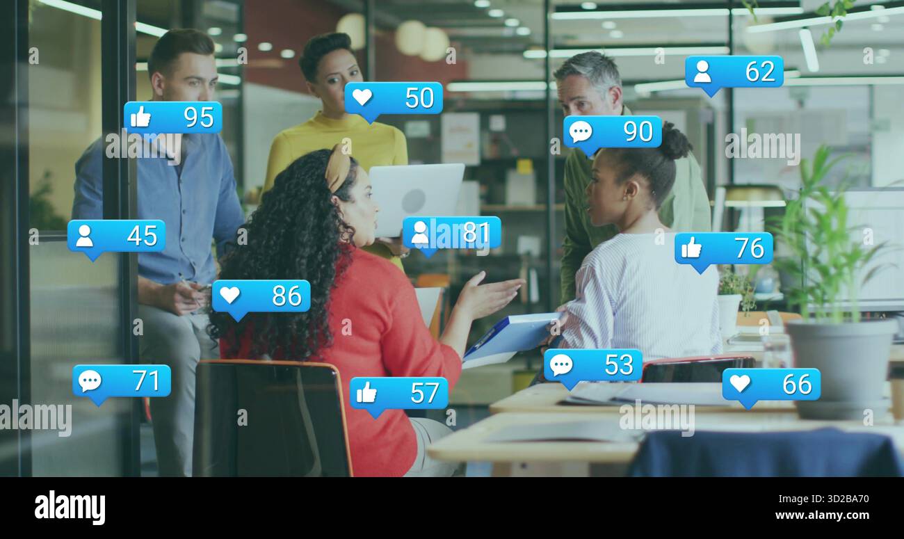 Collaboration cinq professionnels utilisant un ordinateur portable autour de la table dans le bureau sous des icônes numériques flottantes Banque D'Images