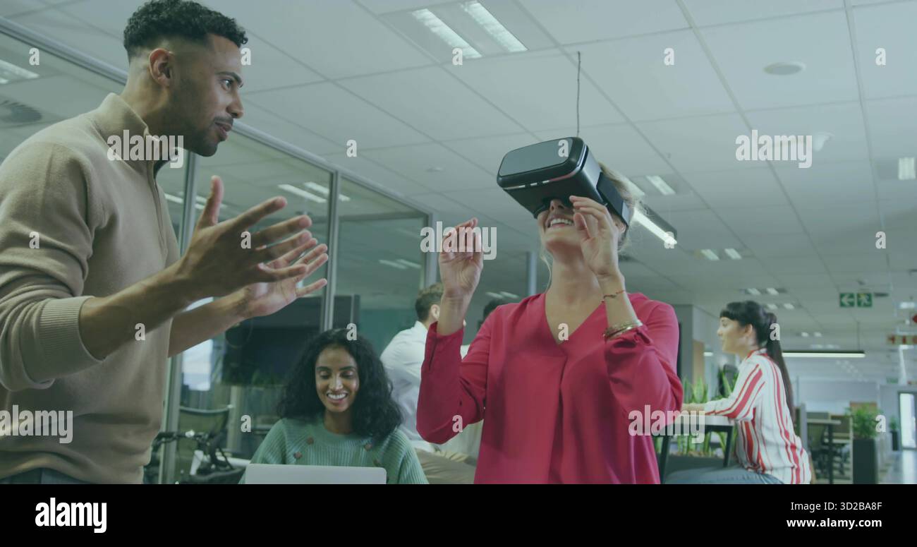 Testeur UX de navigation dans le monde virtuel portant un casque VR au bureau, avec espace de copie sur les ordinateurs portables Banque D'Images