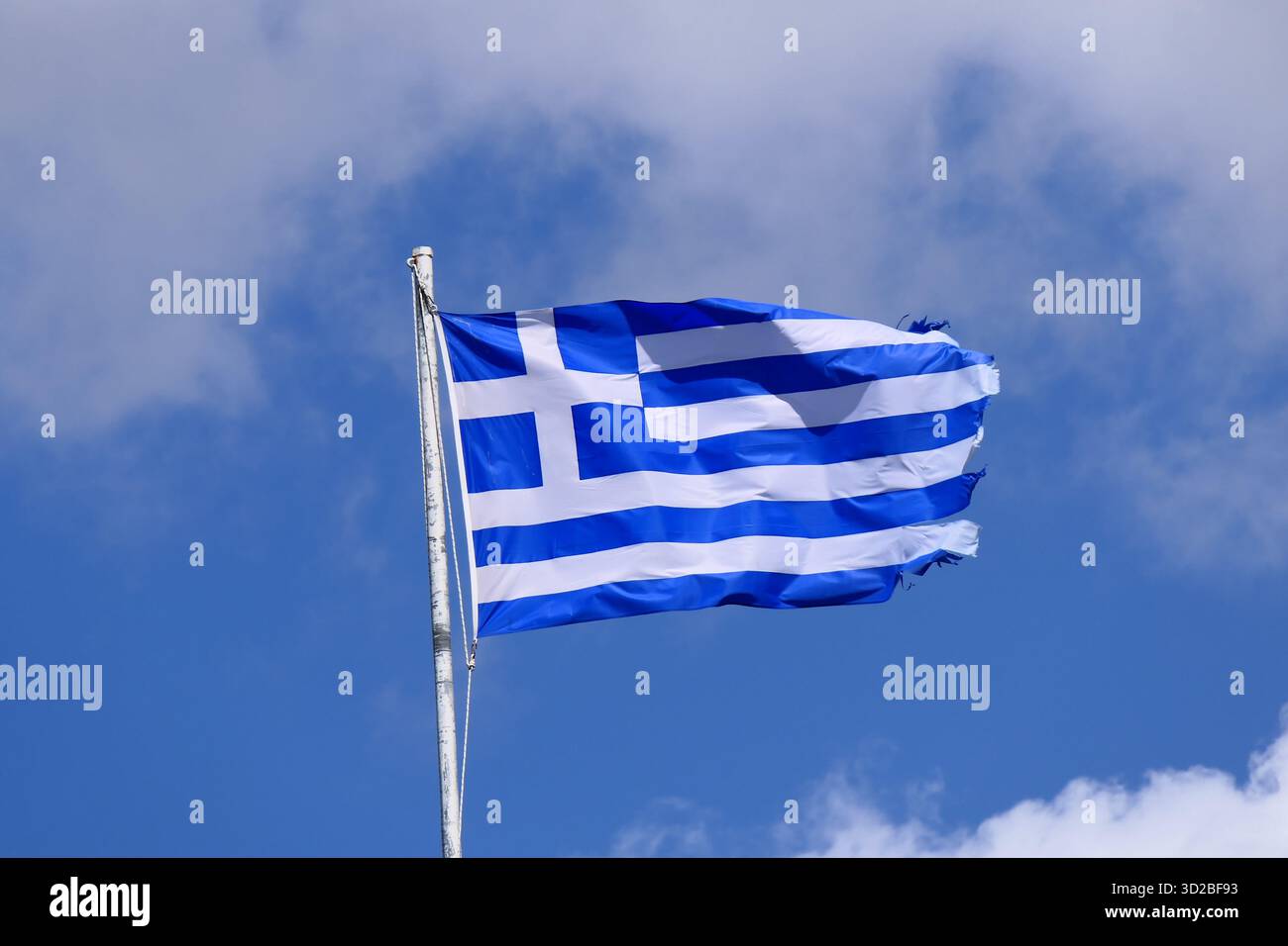 Le drapeau grec bleu et blanc national contre un ciel bleu avec des nuages blancs Banque D'Images