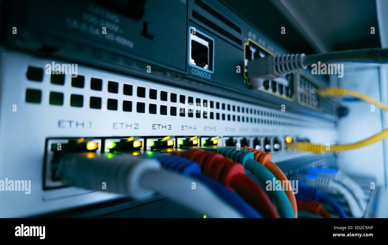 Câbles réseau et lumières incandescentes sur le commutateur de données professionnel, représentant le flux d'informations, la connectivité numérique et l'infrastructure technologique sécurisée Banque D'Images