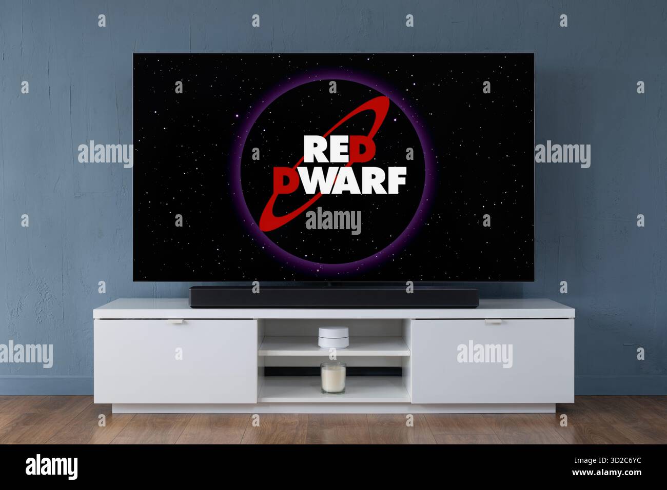 Un téléviseur OLED grand écran montrant la scène d'introduction de la série télévisée Red Dwarf, vue dans un salon contemporain. Banque D'Images