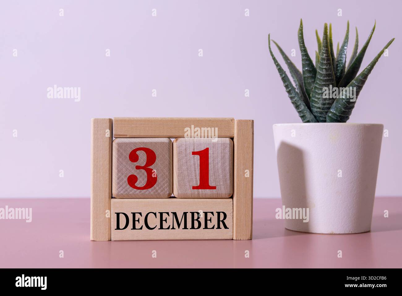 Calendrier mensuel de bureau pour l'année 31 décembre sur table en bois avec verre à café vert Banque D'Images