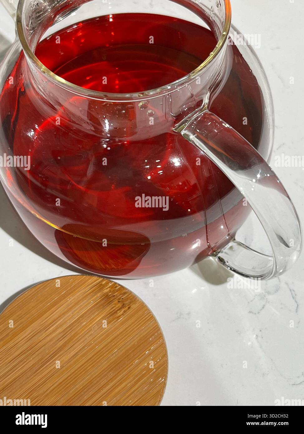 Théière en verre avec thé noir rouge sur fond blanc, vue de dessus - Image de stock capturée avec un smartphone
