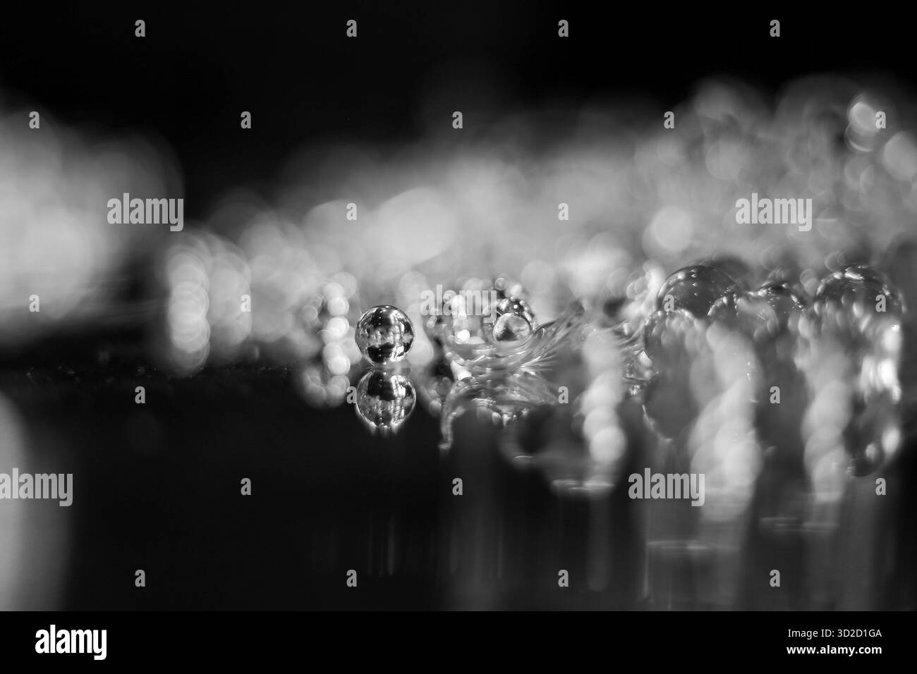 Mise au point sélective, boule de verre claire sur la surface en acier inoxydable, semble belle. Banque D'Images