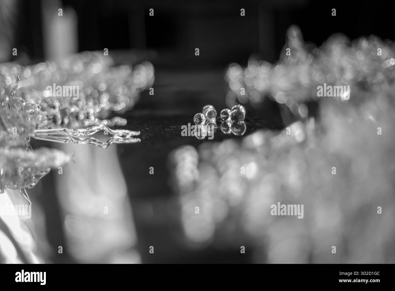 Mise au point sélective, boule de verre claire sur la surface en acier inoxydable, semble belle. Banque D'Images