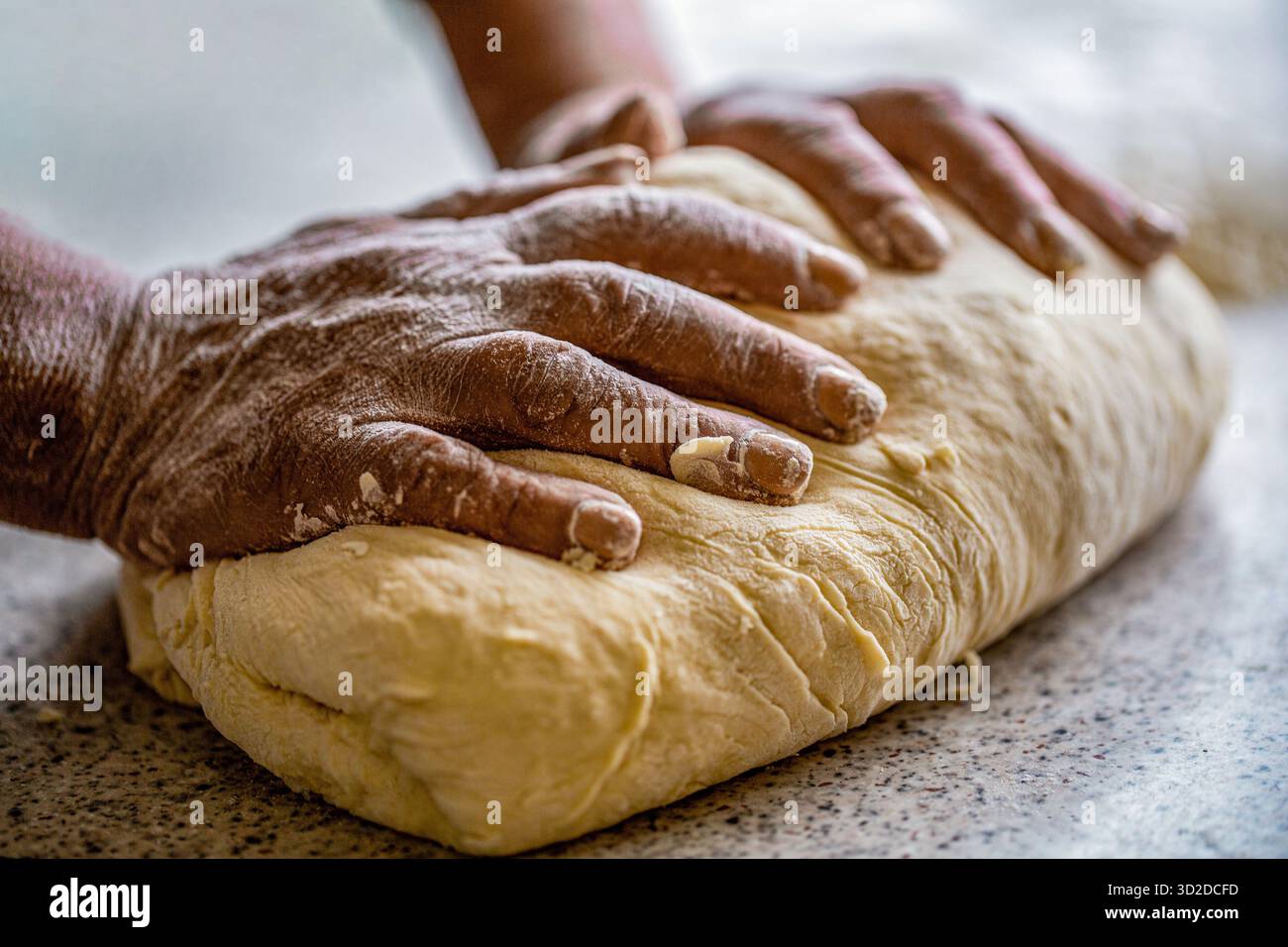 Faire de la pâte par des mains masculines à la boulangerie. Concept alimentaire. Pâte à main. Mains féminines fabriquant de la pâte pour pizza. Chef dans la cuisine professionnelle prépare la pâte Banque D'Images