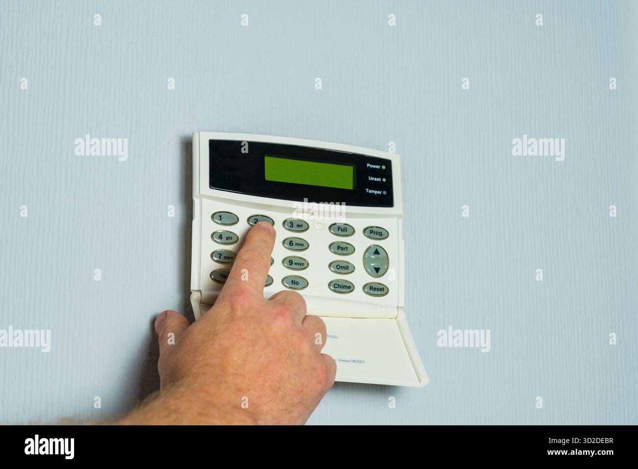 Saisie manuelle du code de sécurité sur un panneau d'alarme de propriété résidentielle, cambriolage à domicile ou concept de crime Banque D'Images