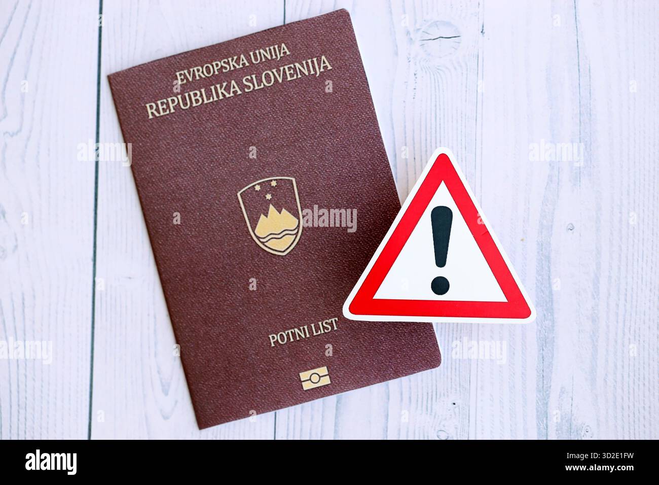 Passeport slovène avec signe d'exclamation sur fond en bois blanc gros plan. Problèmes de citoyenneté en Europe concept Banque D'Images