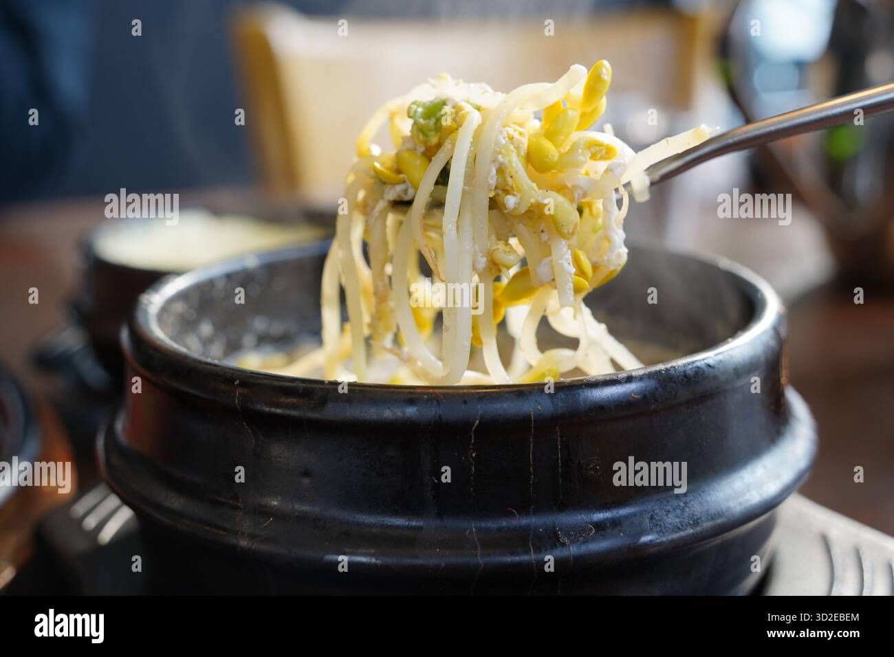 Cuisson à la vapeur d'une soupe de germes de haricots coréens dans un pot en pierre traditionnel Banque D'Images