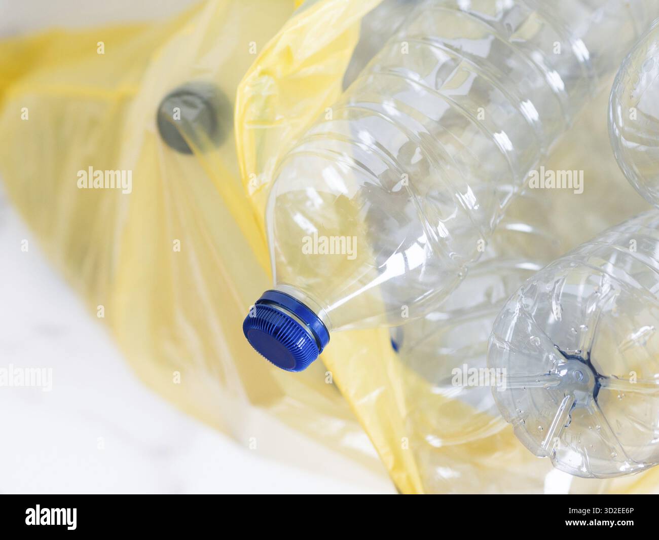 Bouteilles en plastique dans un sac poubelle jaune en attente de recyclage, favorisant la responsabilité environnementale et la gestion des déchets Banque D'Images