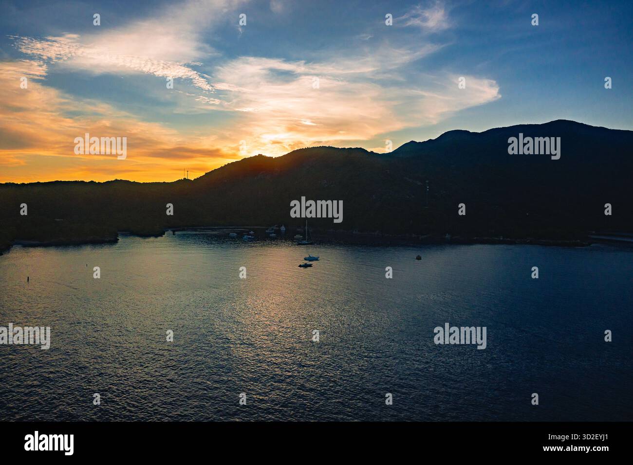 Alors que la première lumière de l'aube se lève sur Haïti, un paysage de lever de soleil à couper le souffle se déploie : les rayons dorés traversent l'horizon, projetant une lueur chaude à travers le Banque D'Images