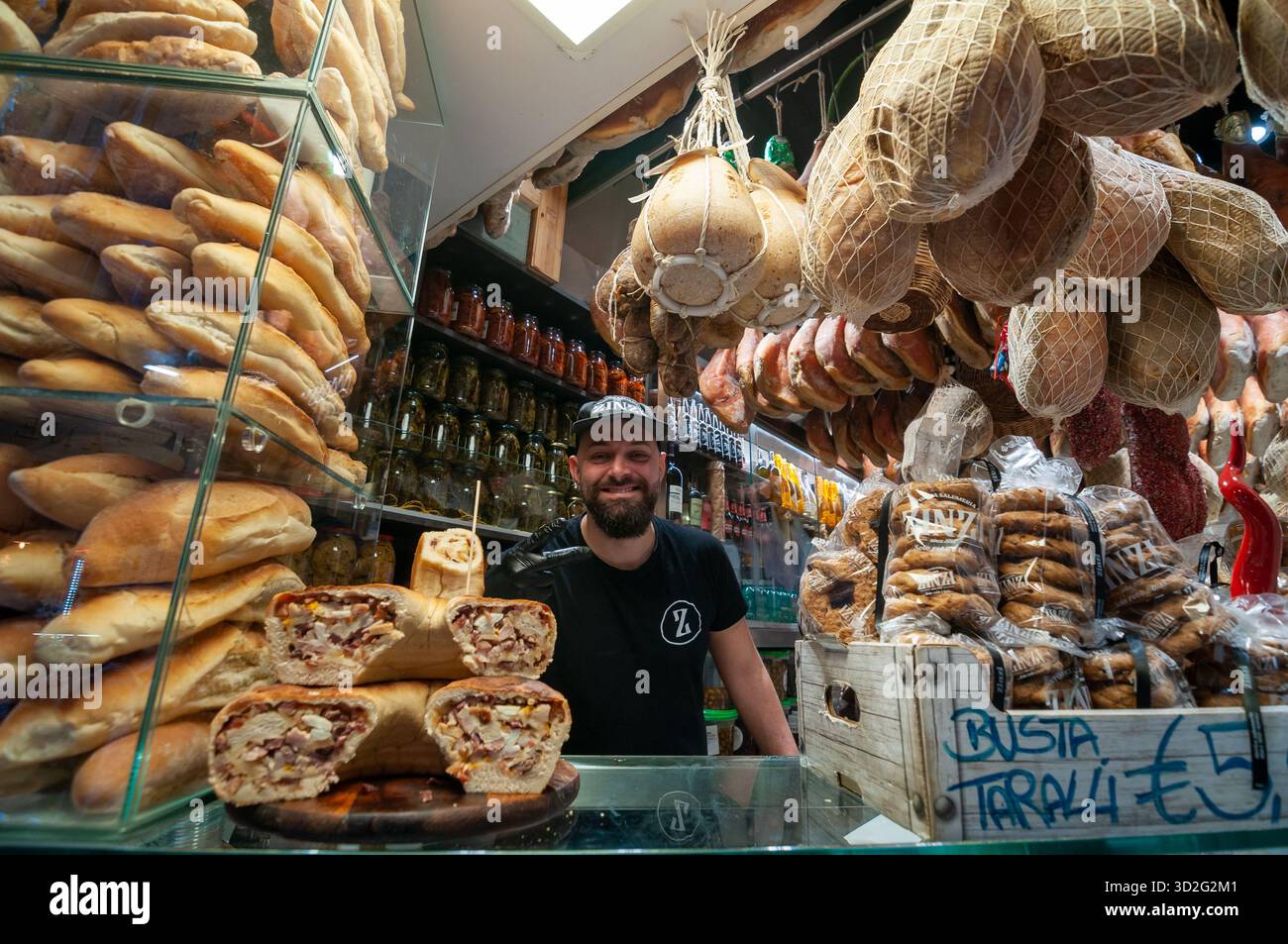 Un sympathique propriétaire d'épicerie fine pose pour une photo dans sa boutique sur la via dei Tribunali, dans le centre historique de Naples. Banque D'Images