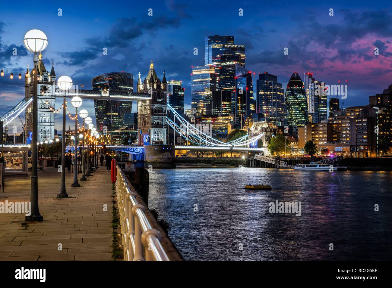 Belle vue en soirée depuis la passerelle de la Tamise jusqu'au Tower Bridge illuminé et à la ville de Londres, en Angleterre Banque D'Images