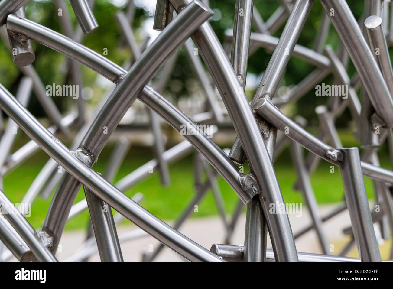 Gros plan d'une sculpture abstraite d'art public faite de tubes brillants en métal chromé argenté soudés ensemble, créant un motif chaotique et complexe. Banque D'Images