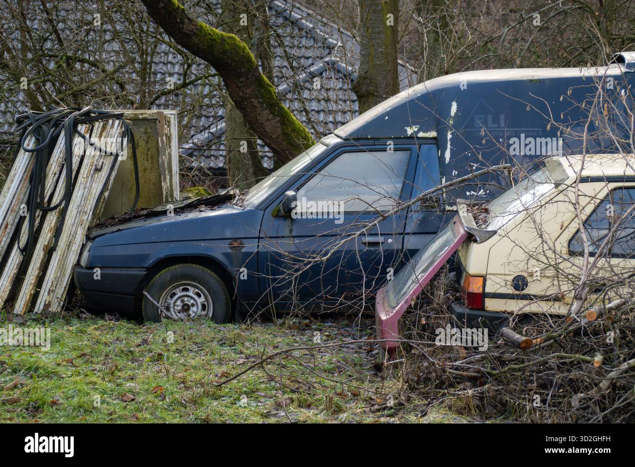 Petrvald, Tchéquie - 26 janvier 2024 : épave de voitures Skoda Favorit jaunes et bleues garées dans la brousse Banque D'Images