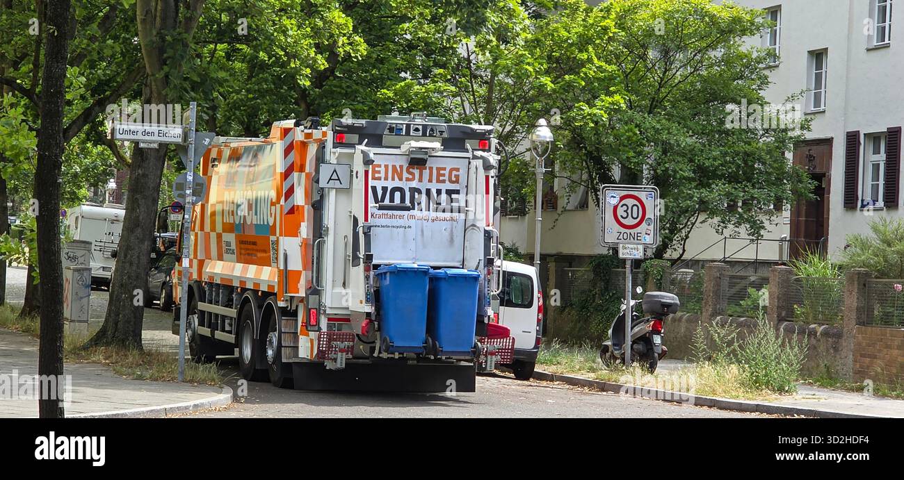 Berlin, Allemagne - 03 juillet 2025 : . Camion poubelle est garé dans la rue avec des bacs de recyclage en milieu urbain entouré de verdure - Image de stock capturée avec un smartphone