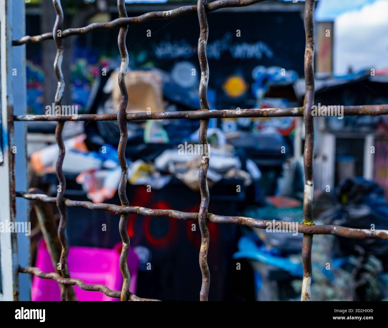 Gros plan d'une grille métallique rouillée devant un site d'élimination illégale de déchets à Berlin, en Allemagne. Banque D'Images