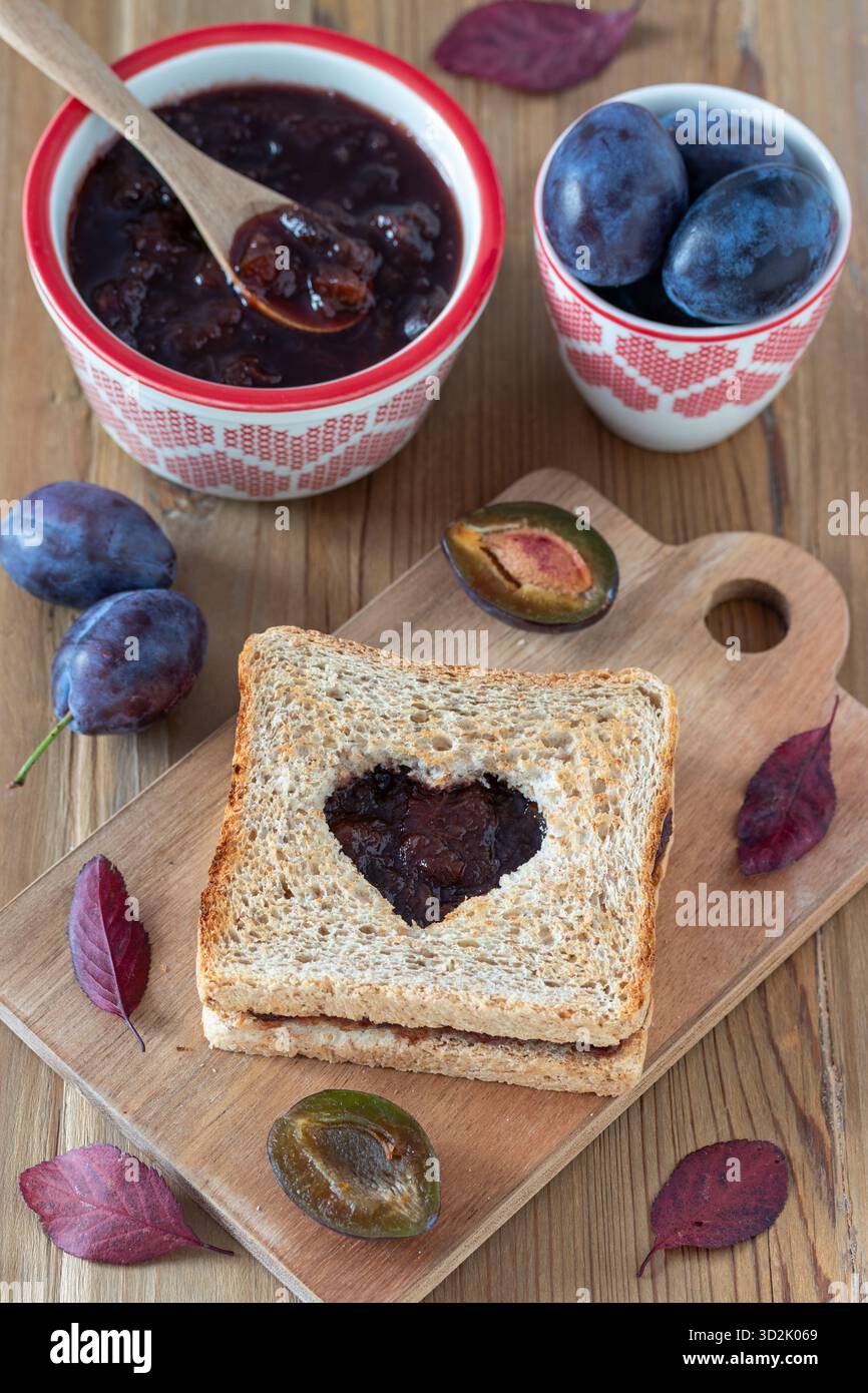 petit déjeuner avec pain grillé à la confiture de prunes, confiture de prunes dans un bol et prunes fraîches Banque D'Images